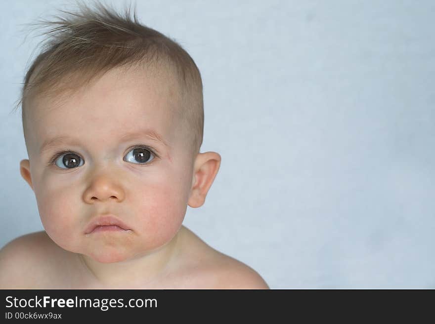 Image of of beautiful baby sitting in front of a white background