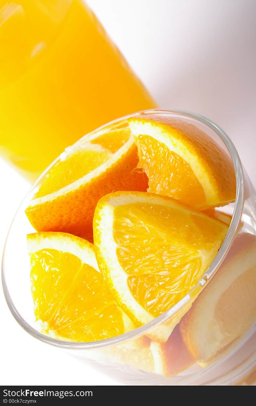 Fresh oranges ready for juicing, with a fresh glass of juice in background. Fresh oranges ready for juicing, with a fresh glass of juice in background.