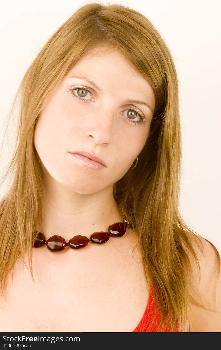 A young woman with a look of surprise against a plain background.