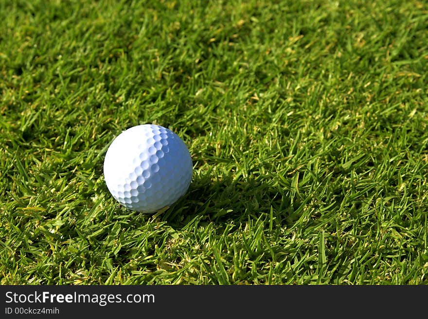 Single golf ball lying on green grass on fairway. Single golf ball lying on green grass on fairway.