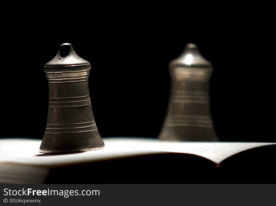 Couple of bells standing on the opened book of Hamlet by Shakespear. Couple of bells standing on the opened book of Hamlet by Shakespear