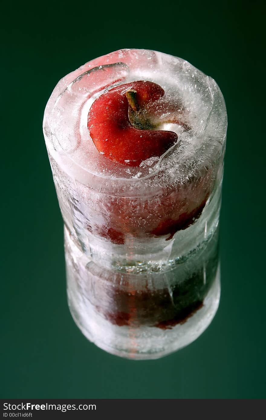 Apple covered with thick ice standing on reflection. Apple covered with thick ice standing on reflection