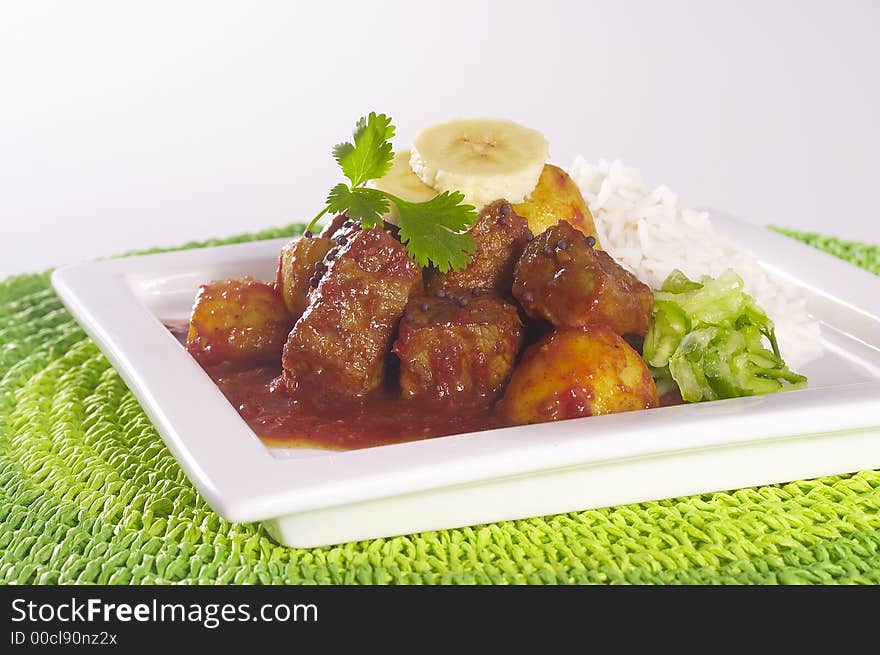 Curry and Rice on white plate with green mat