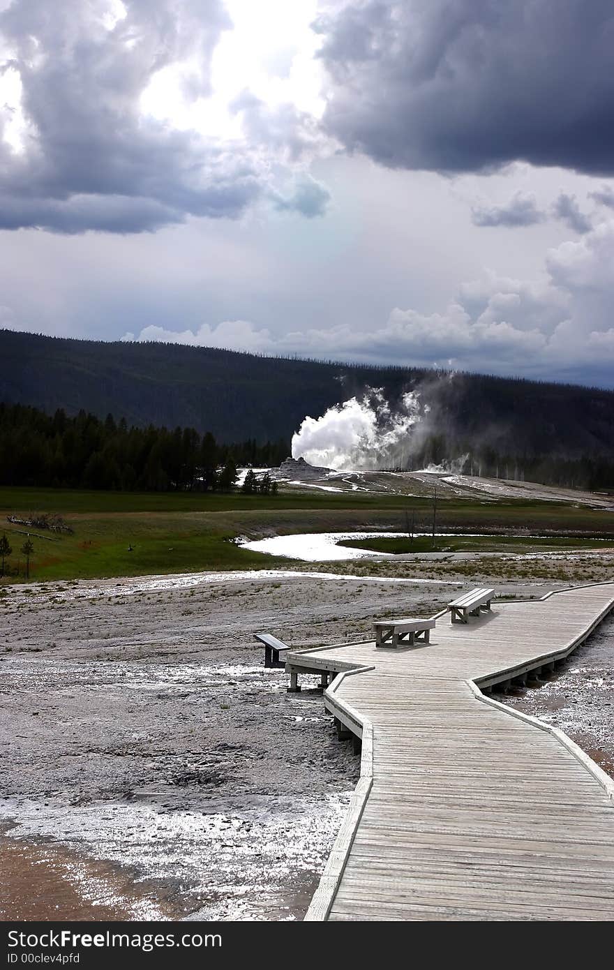 Geyser on walking trail in Yellowstone from long range. Geyser on walking trail in Yellowstone from long range