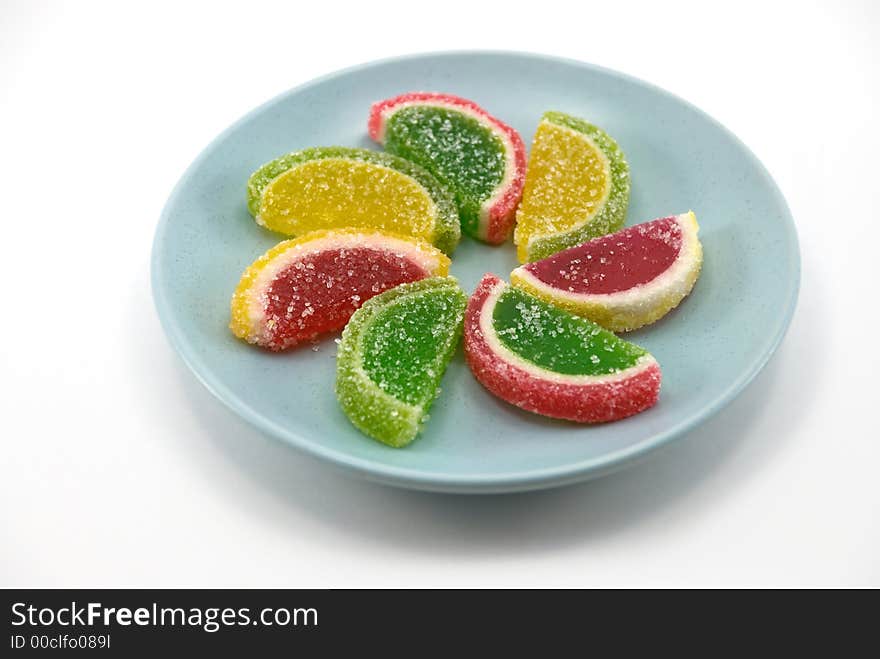 Beautiful fruit candy on a plate on a white background