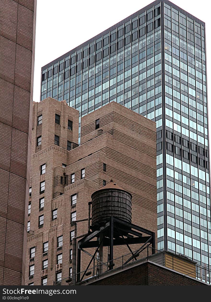 Antique water tank on roof of building in modern city