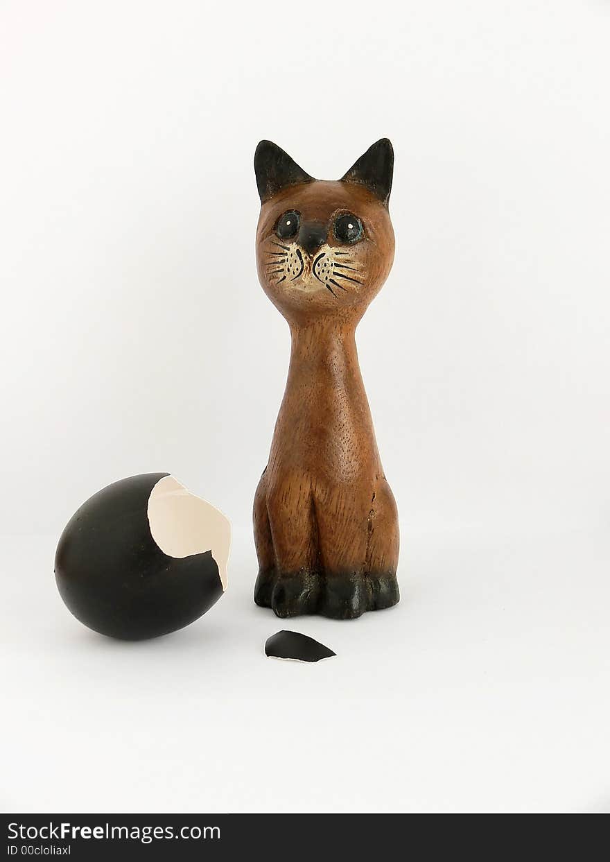 The wooden cat and a broken egg. The wooden cat and a broken egg