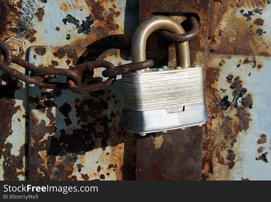 Iron lock and chain on an old rusty door. Iron lock and chain on an old rusty door.