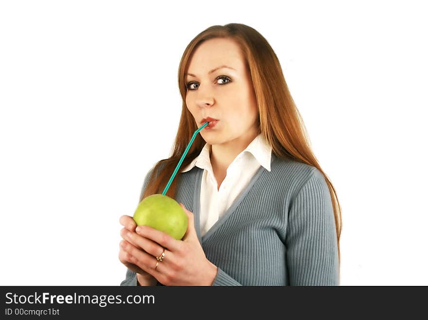 The girl holds in a mouth a tubule for juice which is inserted into an apple. The girl holds in a mouth a tubule for juice which is inserted into an apple