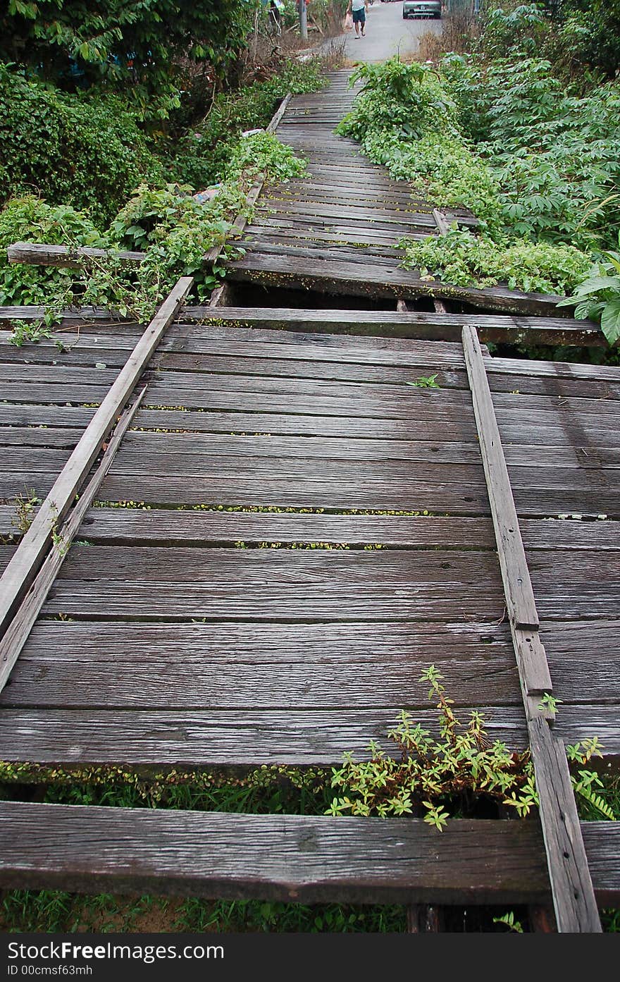 Broken wooden bridge showing missing planks and gaps