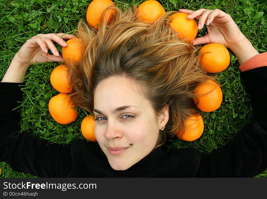 Lady with oranges around her head, smiling, looking ahead. Lady with oranges around her head, smiling, looking ahead