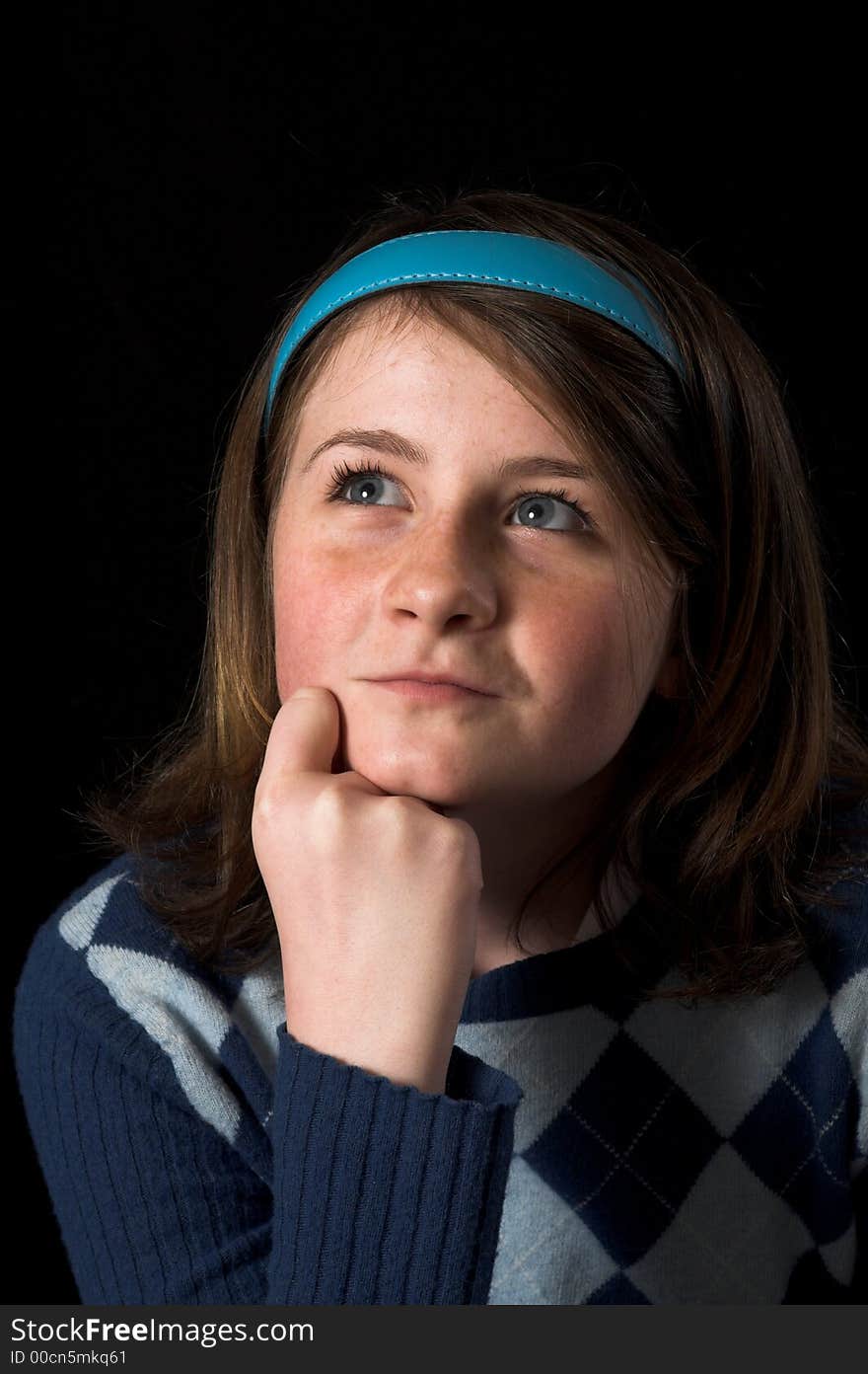 Teen posing over black backdrop