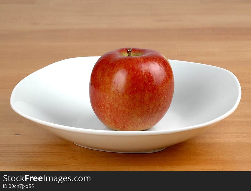 Red Fuji apple in a white bowl. Red Fuji apple in a white bowl.