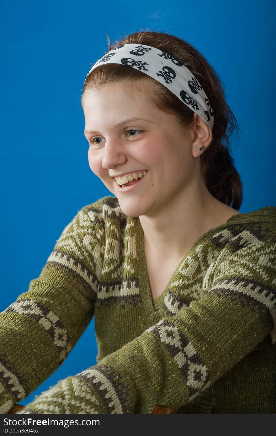 Laughing girl in the sweater against blue background. Laughing girl in the sweater against blue background