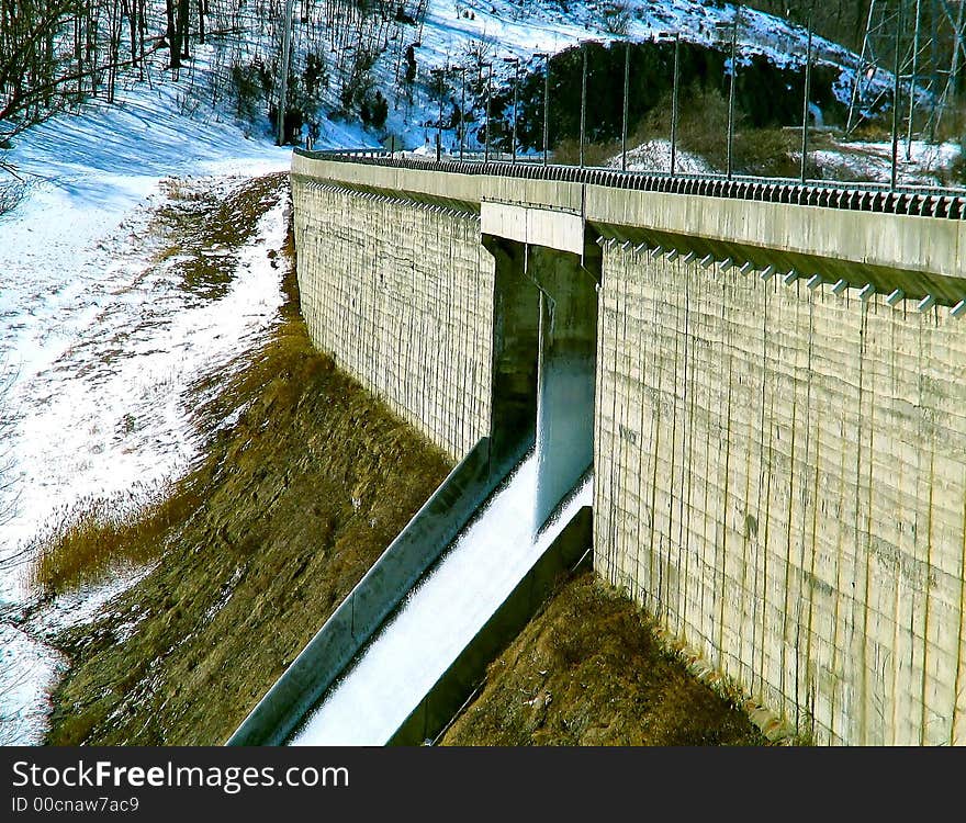 Dam in winter with water flowing