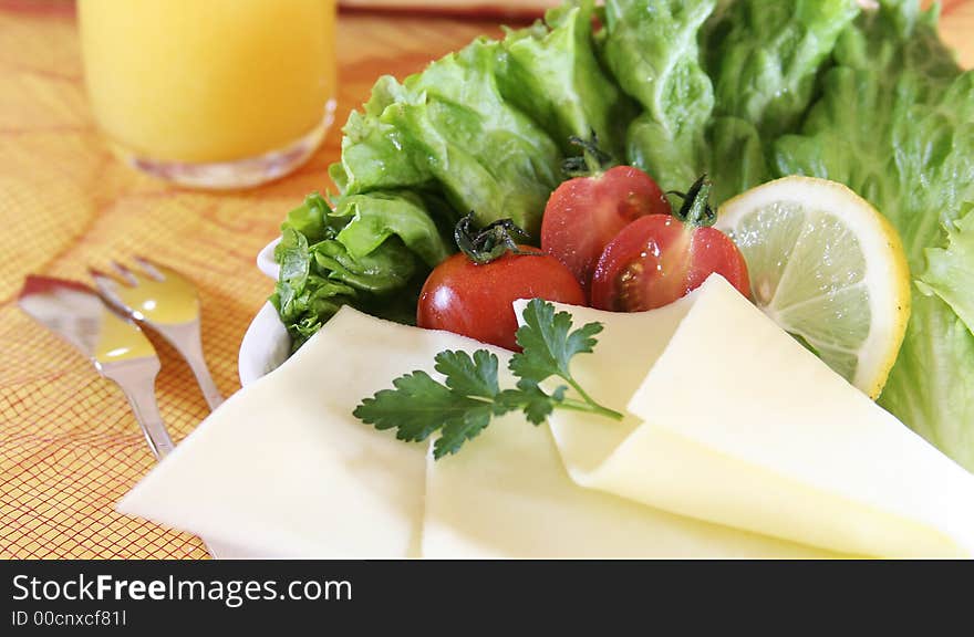 Closeup of fresh salad with cheese and lemon slice.