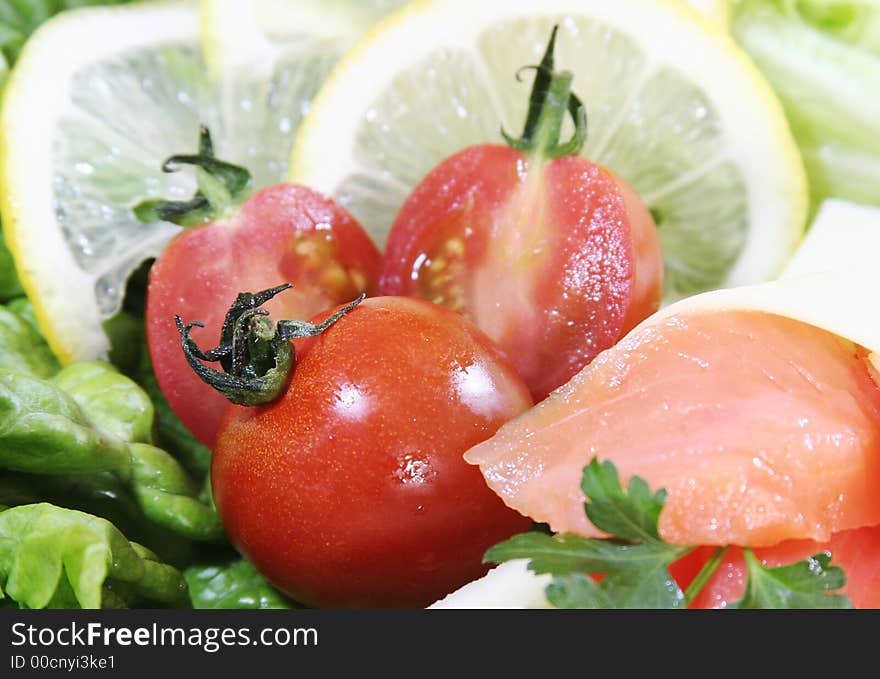 Closeup of fresh salad with cheese and lemon slice.