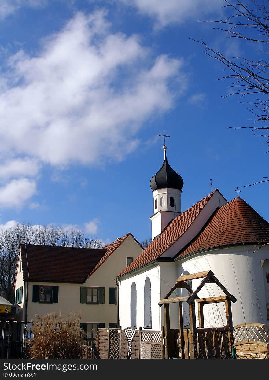 Small european church with building and blue sky. Small european church with building and blue sky