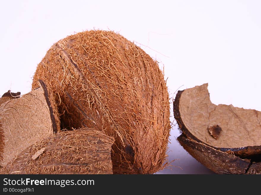 Whole and broken coconut on white background