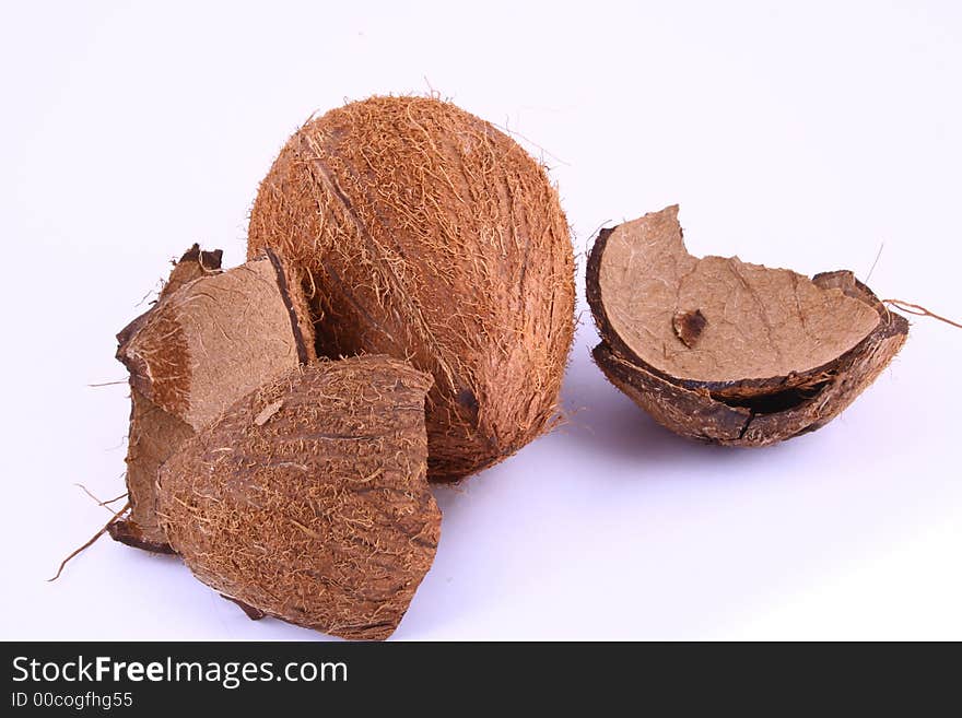 Whole and broken coconut on white background