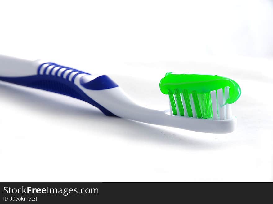 Toothbrush with toothpaste on white background