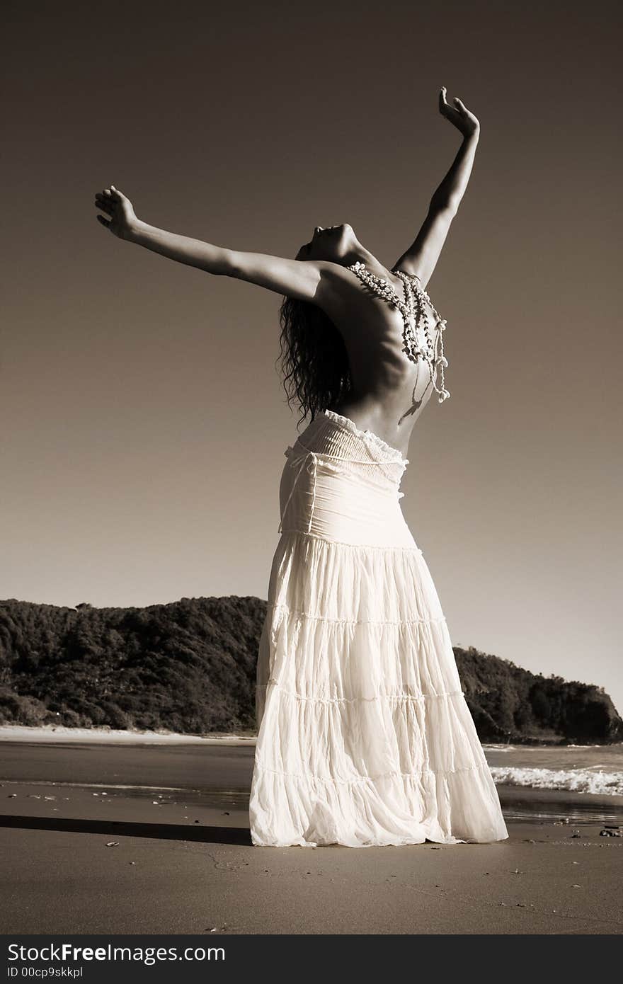 Anonymous girl stretches topless on the beach. Anonymous girl stretches topless on the beach