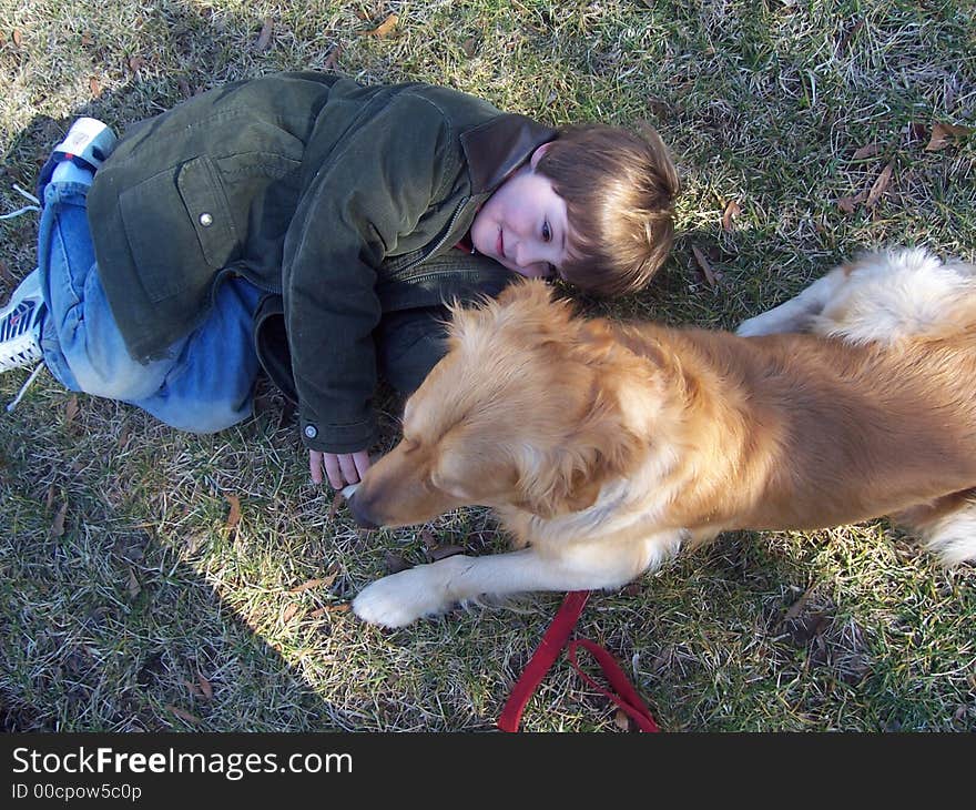 View from above on young boy and golden retriever in field in winter. View from above on young boy and golden retriever in field in winter