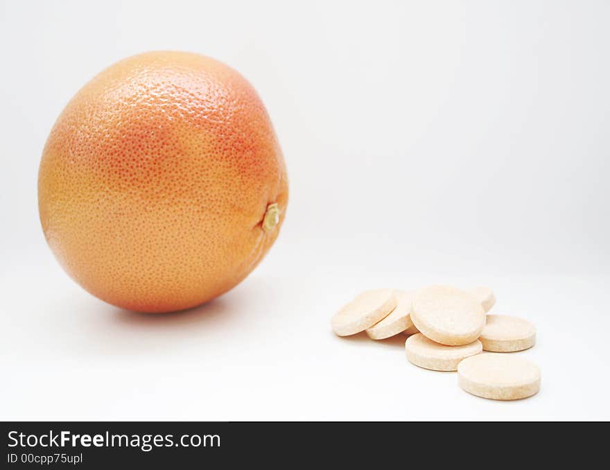 Red grapefruit face pills, on white surface