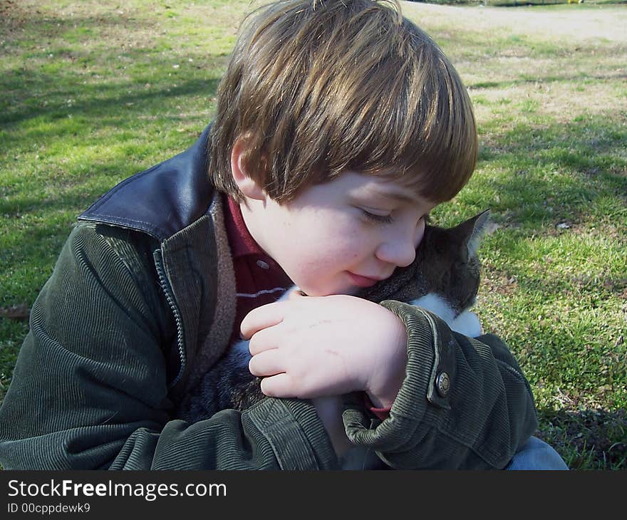 Boy and cat in green grassy field