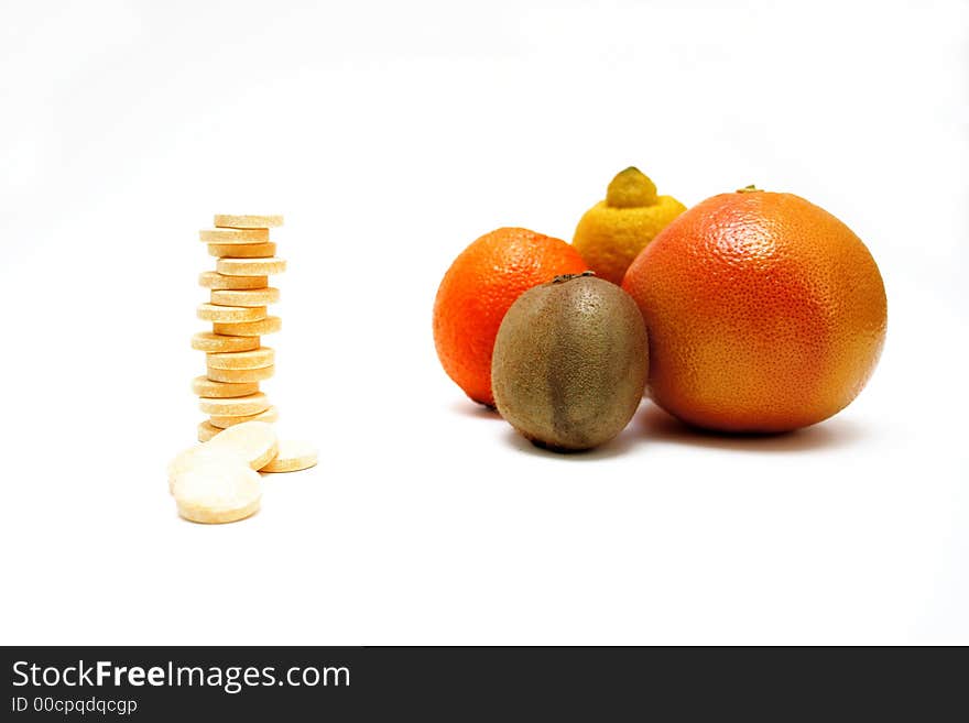 Fresh fruits versus pills, on white surface