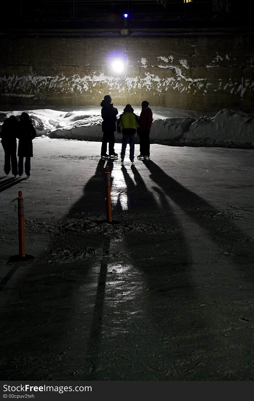 Night image of three backlighted skaters. Night image of three backlighted skaters