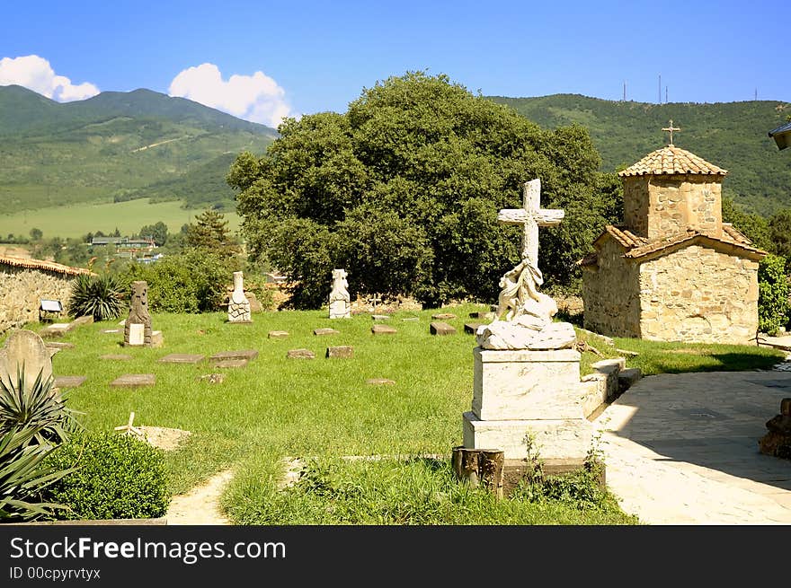 Scenic view of Saint Nino church and cemetery in Samtarvo monastery, Mtskheta, Georgia; countryside in background. Scenic view of Saint Nino church and cemetery in Samtarvo monastery, Mtskheta, Georgia; countryside in background.