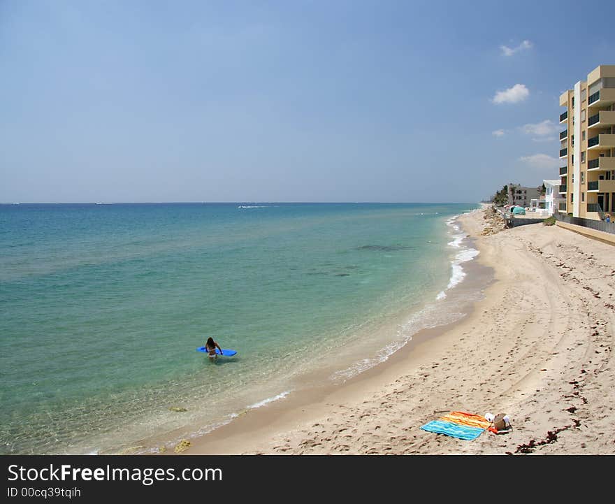 Woman with an air bed on a lonely beach