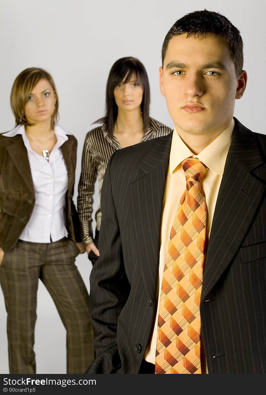 Two women and a man are standing and looking at the camera. There's man-leader at the front of group. Vertical. Two women and a man are standing and looking at the camera. There's man-leader at the front of group. Vertical.