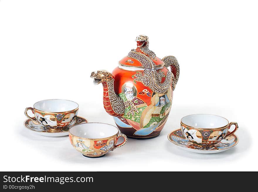 Antique red teapot with dragon and three cups. Antique red teapot with dragon and three cups.