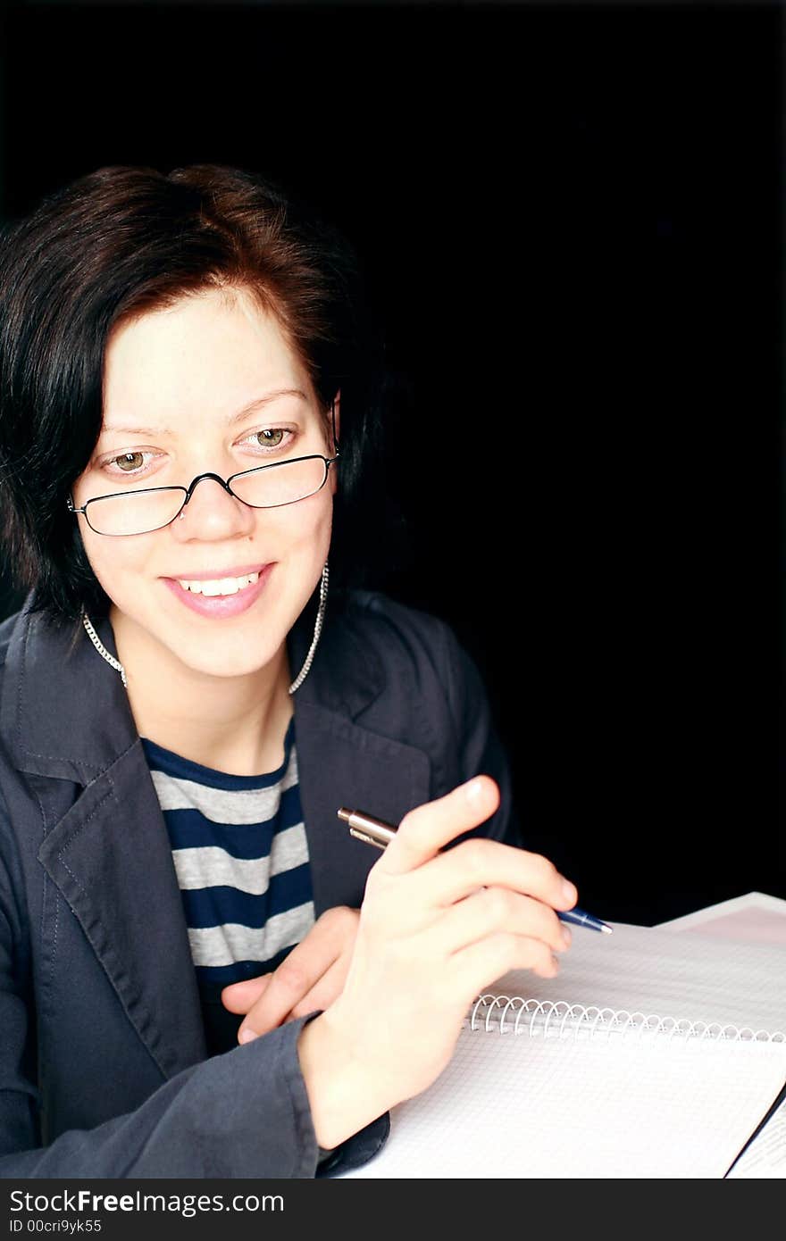 Young woman working, having conversation, note-pad and pen on black background. Young woman working, having conversation, note-pad and pen on black background