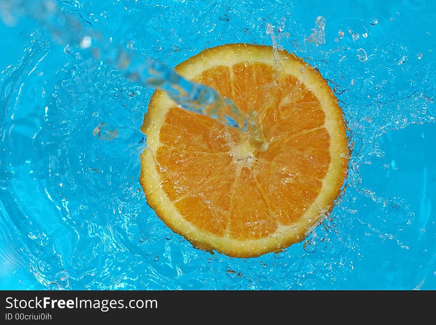 Water splashing on orange in water. Water splashing on orange in water