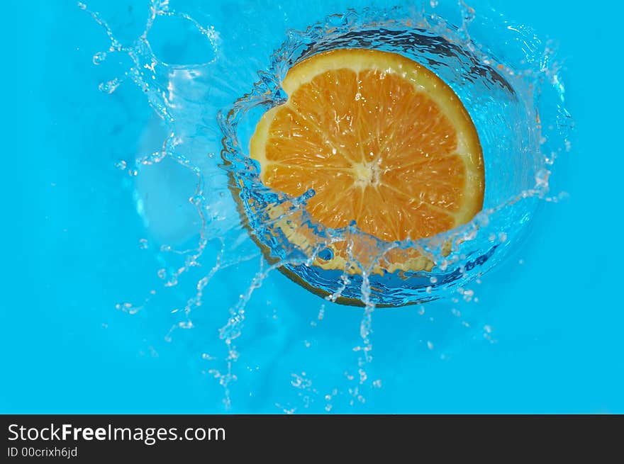 Orange falling in blue water. Orange falling in blue water