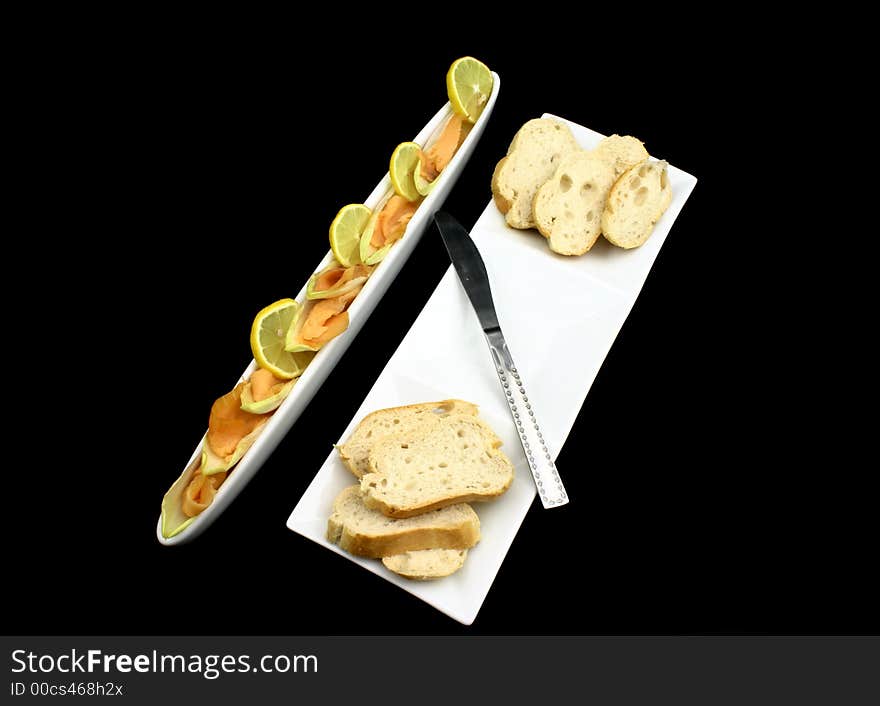 Fresh salmon cut into pieces with chicory and lemon together with bread and knife. Fresh salmon cut into pieces with chicory and lemon together with bread and knife