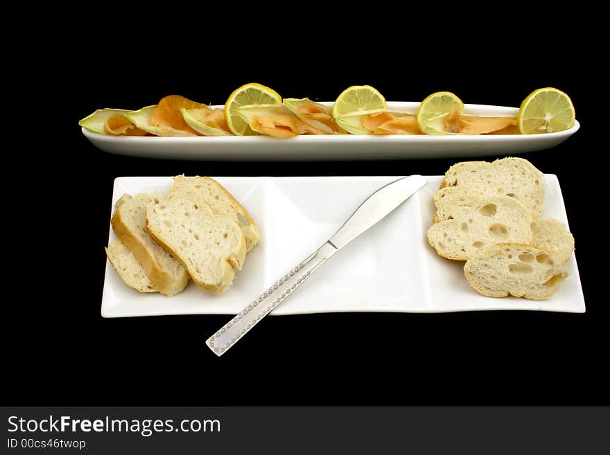 Fresh salmon cut into pieces with chicory and lemon together with bread and knife. Fresh salmon cut into pieces with chicory and lemon together with bread and knife