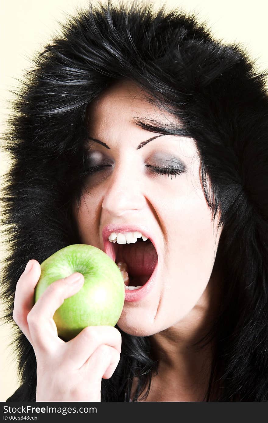 Brunette woman with winter coat and holding a green apple. Brunette woman with winter coat and holding a green apple