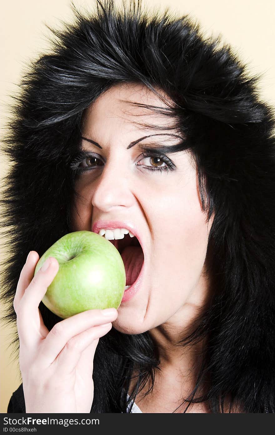 Brunette woman with winter coat and holding a green apple. Brunette woman with winter coat and holding a green apple