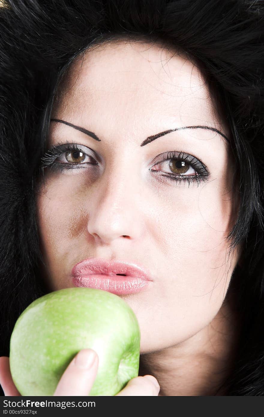 Brunette woman with winter coat and holding a green apple. Brunette woman with winter coat and holding a green apple