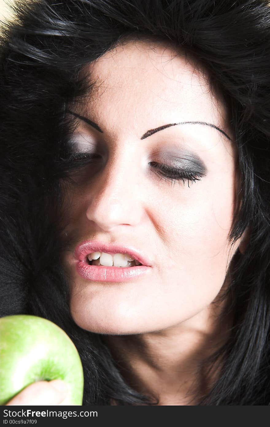 Brunette woman with winter coat and holding a green apple. Brunette woman with winter coat and holding a green apple