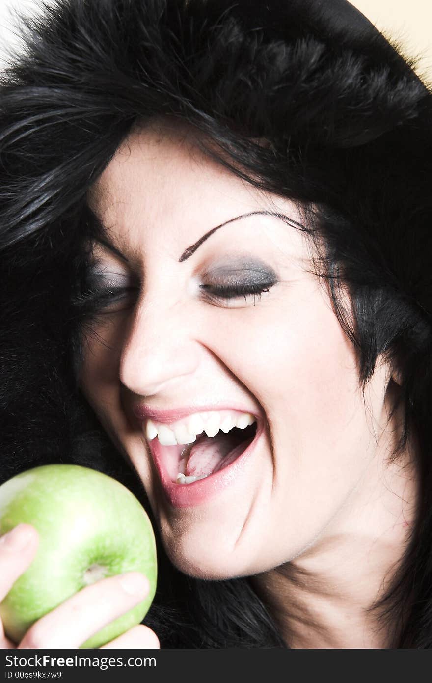 Brunette woman with winter coat and holding a green apple. Brunette woman with winter coat and holding a green apple