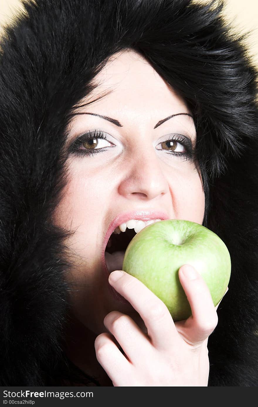 Brunette woman with winter coat and holding a green apple. Brunette woman with winter coat and holding a green apple