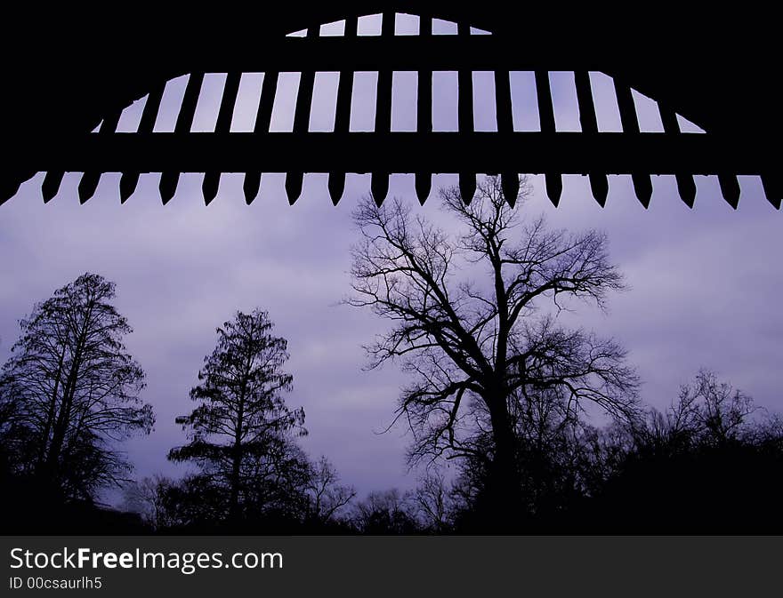 Silhouette of medieval open gate, with trees at the background. Silhouette of medieval open gate, with trees at the background.