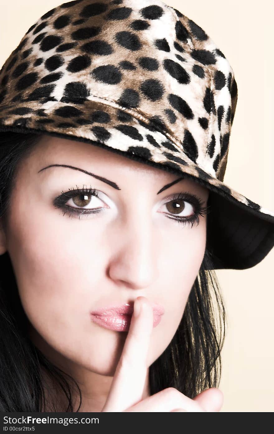 Beautiful brunette young woman gestures for silence, shh