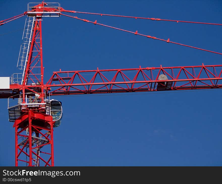 Construction Crane with focus on operator area.  Red on blue. Construction Crane with focus on operator area.  Red on blue.