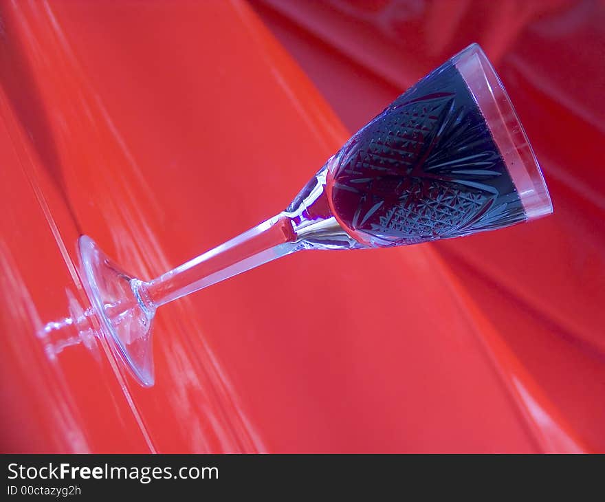 Tall glass with black drink on red background. Tall glass with black drink on red background